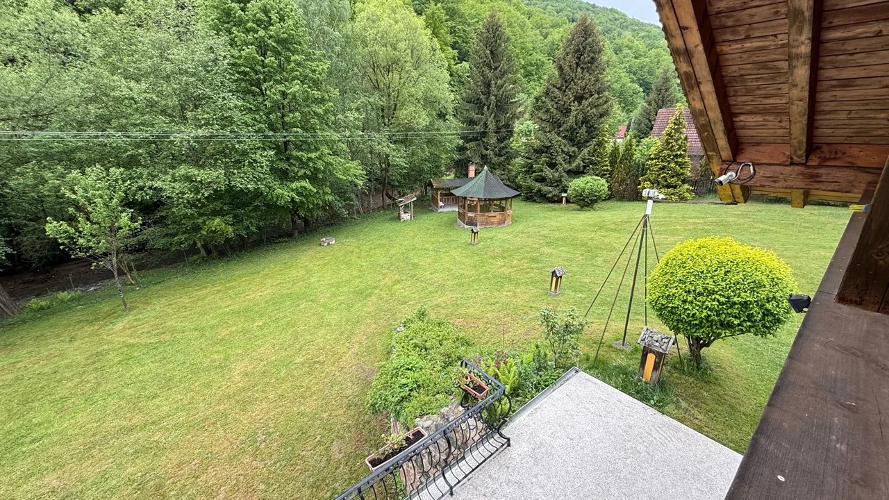 Priveliște de pe balcon spre poiană, foișor și marginea râului